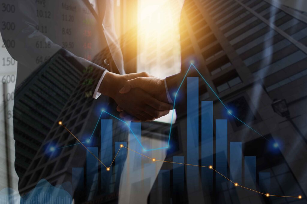 “Business professionals shaking hands over successful finance deal with digital stock market and investment data overlay “